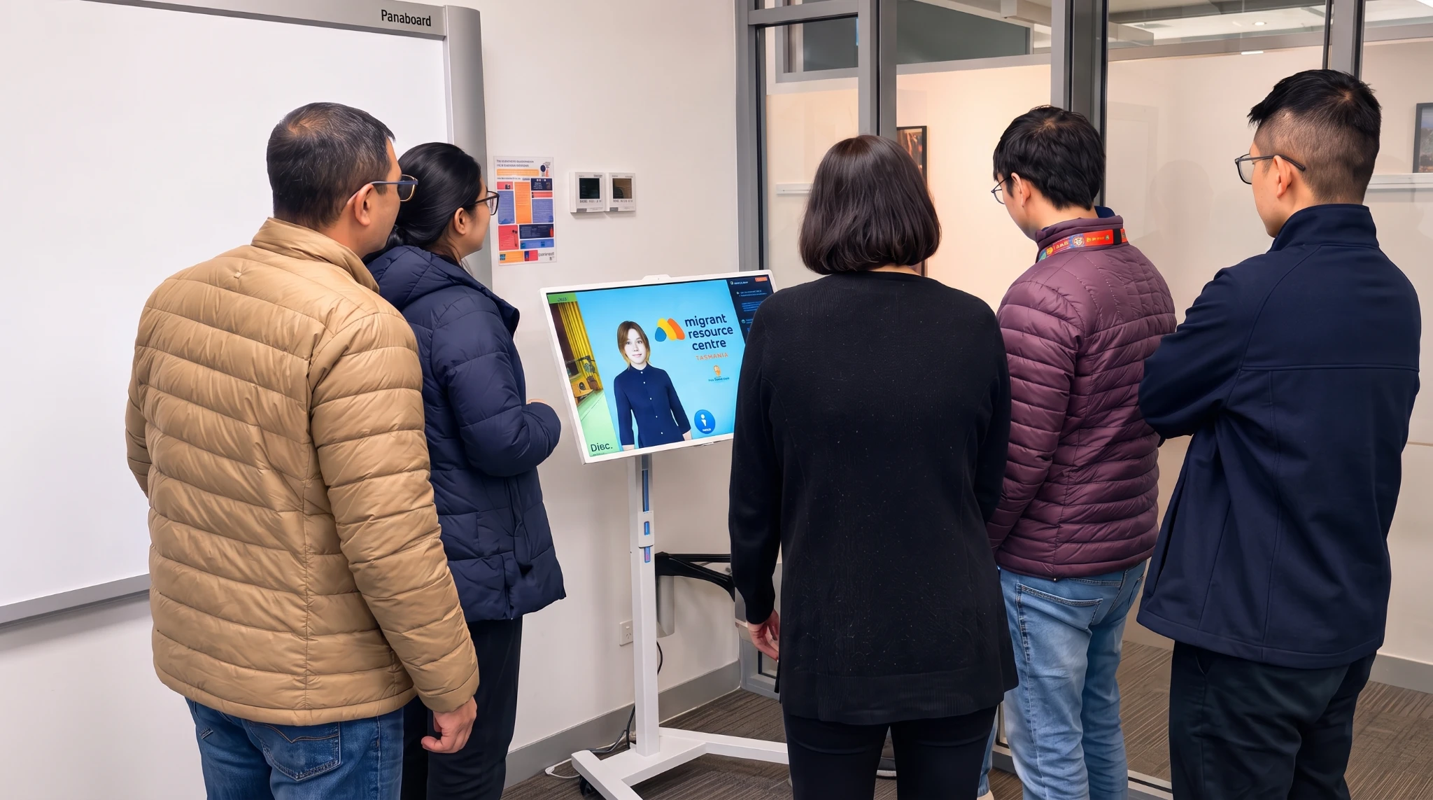 A group of people viewing the Matilda digital human kiosk at Migrant Resource Centre Tasmania